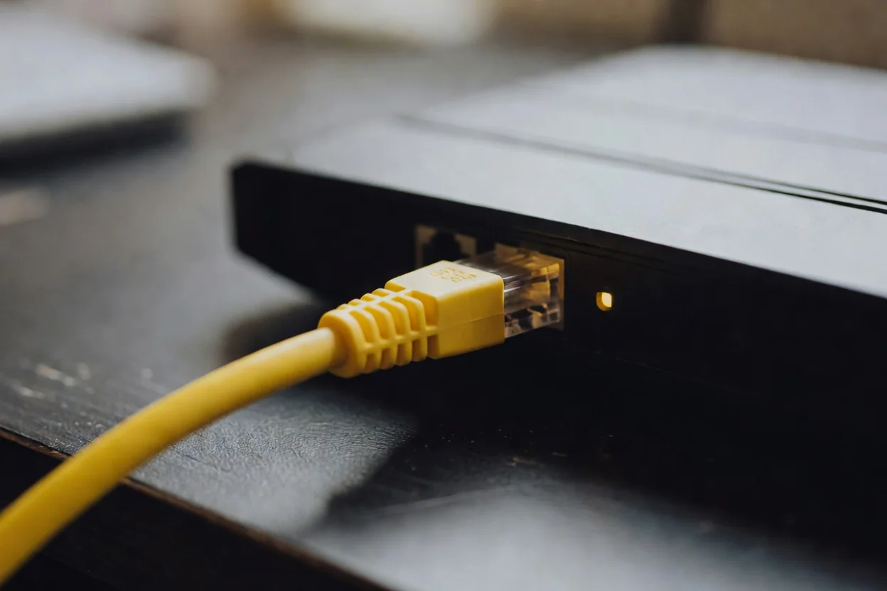 An ethernet cable plugged into a home router, close-up